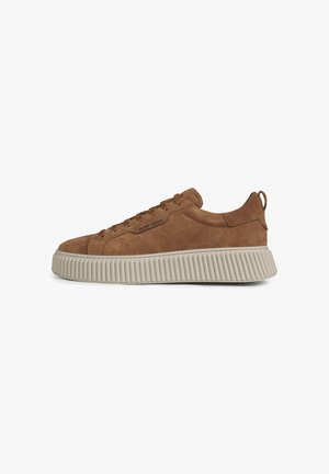 Brauner Wildleder-Low-Top-Sneaker mit dicker gerippter beiger Sohle und Zuglasche an der Ferse, Schnürung vorne, von der linken Seite gezeigt.