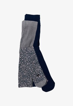 Három pár zokni: egy sötétkék, egy szürke mintás, és egy egyszínű sötétkék, megerősített lábujjal. Kötött anyagból, puha textúrával.
