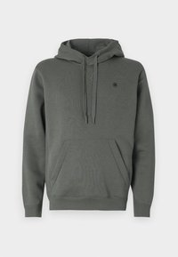 Hoodie en coton vert foncé avec une poche kangourou, capuche réglable avec cordon, et logo discret sur la poitrine ; texture lisse et coupe décontractée.