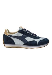 Sneaker in suede blu navy con accenti grigio chiaro, design perforato e tallone in pelle beige. Suola in gomma spessa con un motivo testurizzato.