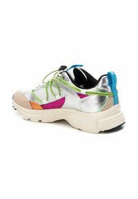 Zapatilla plateada con acentos multicolores en rosa, naranja y verde. Presenta detalles de malla, una suela gruesa y materiales texturizados.