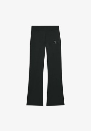 Leggings noires évasées en tissu extensible, avec un logo en argent décoratif sur la hanche avant gauche et une taille lisse.