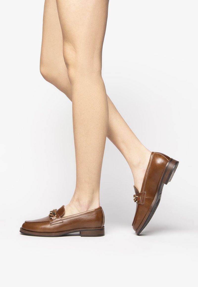 Braune Lederloafer mit runder Spitze, dekorativer Hardware und niedrigem Holzabsatz, die eine glatte Textur und klare Linien zeigen.
