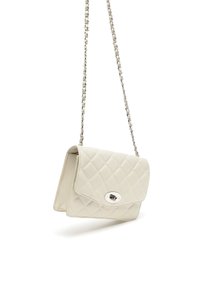 Borsa a tracolla in crema trapuntata con catena in argento e chiusura a scatto, caratterizzata da un accento metallico rotondo sulla parte frontale.
