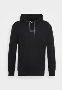 Sudadera negra fabricada en material suave, con capucha ajustable y detalles en rosa, y un logo blanco de Calvin Klein en la parte frontal. Corte clásico.