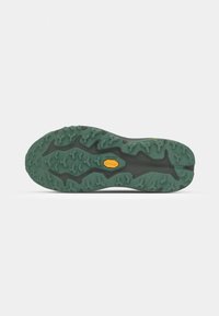 Zöld gumitalp, texturált talpmintával, középen fekete csíkkal és sárga Vibram akcentussal. Összességében robusztus kialakítás.