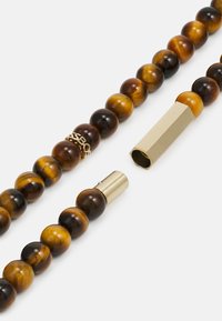 Tiger's eye perlekæde med guldfarvet hexagonale og cylindriske hardware, der har vekslende mørkeblå og lysebrune kugleperler.