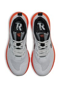 Grijze sportschoenen met een oranje zool, voorzien van een ademende gebreide bovenkant, ronde neus en contrasterende zwarte accenten op de binnenzool en veters.