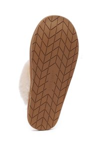 Tan rubber sole with a textured herringbone pattern, showcasing a soft, cream-colored plush upper attached along the edge.