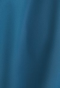 Blauwe stof met een gladde textuur en een lichte glans, die een uniforme kleur vertoont zonder zichtbare patronen of hardware.