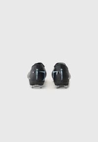 Des chaussures de football noires au design épuré, avec un upper texturé, un bout arrondi et six crampons métalliques sur la semelle. Des accents bleus sont visibles.