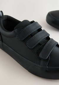 Czarne skórzane buty z trzema paskami na rzep, gładką fakturą, okrągłym noskiem i solidną gumową podeszwą. Minimalistyczny design bez dodatkowych akcentów.