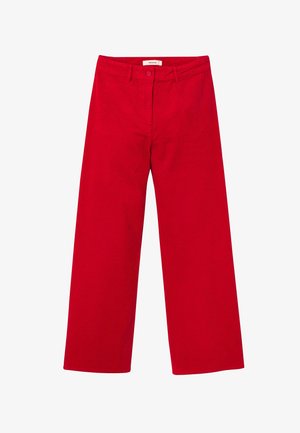 Pantalons larges rouges en velours côtelé, avec une texture lisse, une fermeture à bouton et des poches avant, présentant un design épuré et minimal.
