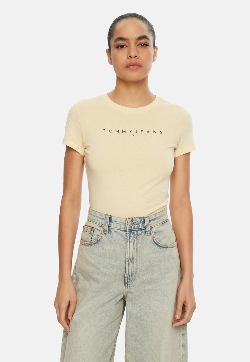 Camiseta de algodón amarilla con mangas cortas y cuello redondo, con texto "TOMMYJEANS" en negro en el pecho.