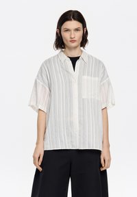 Lightweight, button-up shirt featuring vertical light gray and white stripes, short sleeves, and a chest pocket. Smooth texture.