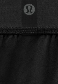 Mustast kangast, millel on sile tekstuur, on kogutud äär ja väike hall logo. Kujundus rõhutab lihtsust ja funktsionaalsust.