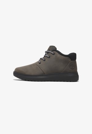 Dunkelgraue Leder-Sneaker mit grauen Schnürsenkeln, niedrigem Schnitt, abgerundeter Spitze, schwarzer Gummisohle und Baum-Logo auf der Ferse. Glatte Textur.