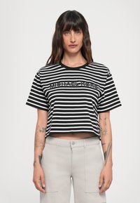 Stripete svart og hvit kortermet t-skjorte med "MICHAEL KORS" brodert foran, med korte ermer og rund hals.