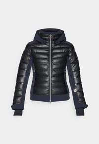 Giubbotto imbottito nero con finitura in pelle lucida, accenti blu navy, cappuccio e tasche con zip. Presenta polsini a coste e un dettagli metallici del logo.