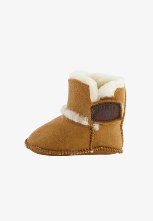 Beige Wildlederstiefel mit Kunstfellfutter, abgerundeter Zehenpartie und gesticktem Detail. Auf der Seite befindet sich ein rechteckiges Lederetikett mit Logo.