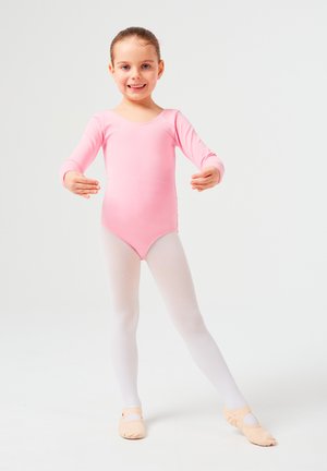 Rosa Langarm-Body mit einem Rundhalsausschnitt, kombiniert mit weißen Strumpfhosen und hellrosa Ballettschuhen, an einer jungen Tänzerin vor einem neutralen Hintergrund.