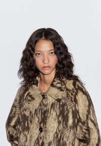 Wollmischungs-Mantel mit einem braunen und beigen Tiermotiv, großem Kragen und schwarzen Knöpfen, entworfen mit einer lockeren Passform.