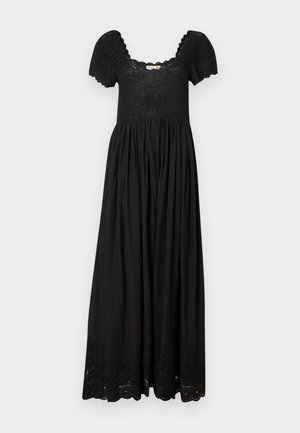 Fekete maxi ruha texturált kivágással, rövid puffos ujjakkal és gyűrt szoknyával, amelyen finom lyukacsos részletek találhatóak az alján.