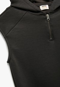 Sort ærmeløs hoodie med lynlås foran, lavet af tekstureret stof. Har en hætte og en labelmærke med teksten "Koton Kids" og størrelsesindikation.