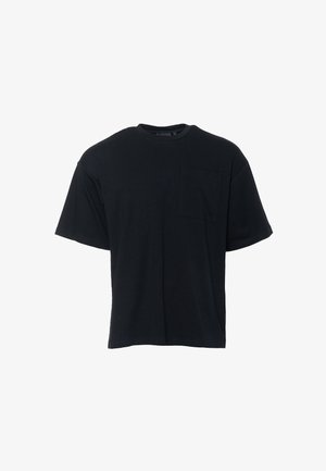 Camiseta de algodón negra con cuello redondo, mangas cortas y un bolsillo en el pecho. Presenta un ajuste relajado y rectangular, así como una textura suave.