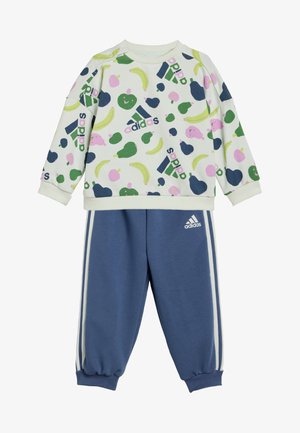 Conjunto de dos piezas de Adidas que incluye una sudadera de color claro con patrones de frutas y pantalones de chándal azul marino con rayas blancas en los laterales y puños.
