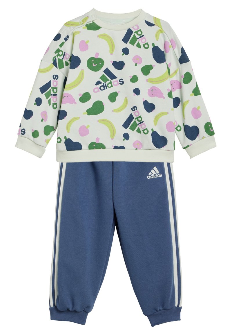 Conjunto de dos piezas de Adidas que incluye una sudadera de color claro con patrones de frutas y pantalones de chándal azul marino con rayas blancas en los laterales y puños.