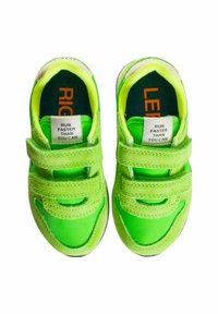 Sneakers verde brillante con due cinturini in velcro, tomaia in tessuto, etichette interne in contrasto nero e arancione, punta arrotondata e suola in gomma testurizzata.
