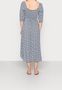 Květinové midi šaty se smockovaným živůtkem, krátkými nabíranými rukávy a širokým otevřeným zádovým výstřihem. Námořnická základní barva s modrými a bílými květinovými vzory.