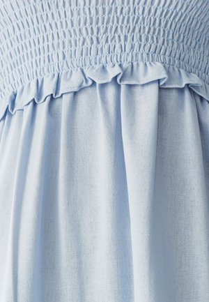 Šviesiai mėlynas surinkto audinio, su raukšlėtu apdailu, pasižymintis struktūrizuota paviršiumi ir susiraukšlėta detale, sukuriantis atsipalaidavusį drapiravimą.