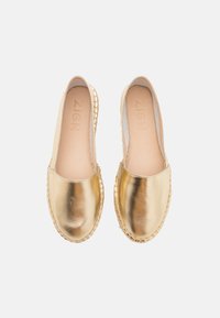 Espadrilles métalliques dorées avec une finition lisse, bout rond et détails en jute tressé le long de la semelle. Logo visible sur la semelle intérieure.