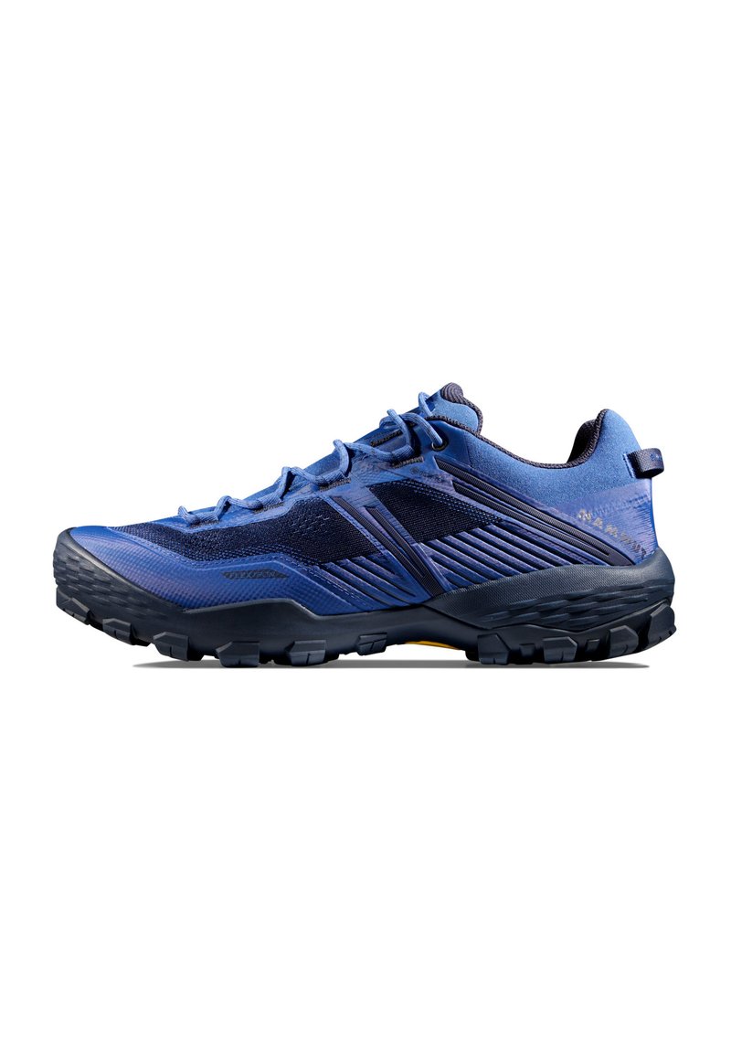 Blå trailrunning-sko med övre i mesh, texturerade överlägg och gummisula. Utmärks av förstärkt tåskydd och kontrasterande hälrem.