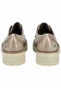 Scarpe sintetiche beige con finitura testurizzata, tacco rialzato e perforazioni decorative sui lati; dotate di suole chiare e dettaglio del logo.