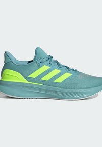 Zapatilla deportiva con una parte superior de malla en color azul verdoso, tres franjas amarillas-verdosas y una suela texturizada y acolchada para mayor comodidad.