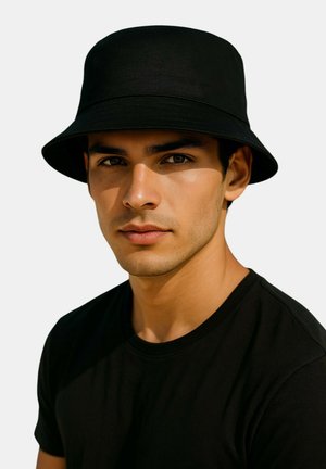 Young man with medium skin tone wearing a black bucket hat and black t-shirt, looking directly ahead against a plain background.