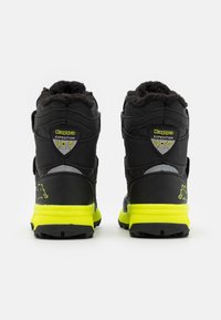 Czarne i szare buty trekkingowe z puszystym kołnierzem, z jaskrawożółtą podeszwą i akcentami oraz logo z tyłu.