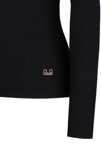 Zwarte geribbelde longsleeve top met een slanke pasvorm. Kenmerkt zich door een gouden logo detail aan de onderkant, wat de textuur van de stof accentueert.