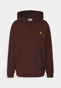 Tummanpunainen huppari, jossa on etupuolella kengurun tasku, kiristysnaruilla varustettu huppu ja pieni brodeerattu logo rinnassa. Pehmeä, puuvillasekoitekangas.