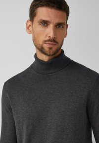 Ciemnoszary sweter z golfem wykonany z miękkiej dzianiny. Posiada długie rękawy oraz dopasowany krój z prążkowanym kołnierzem.