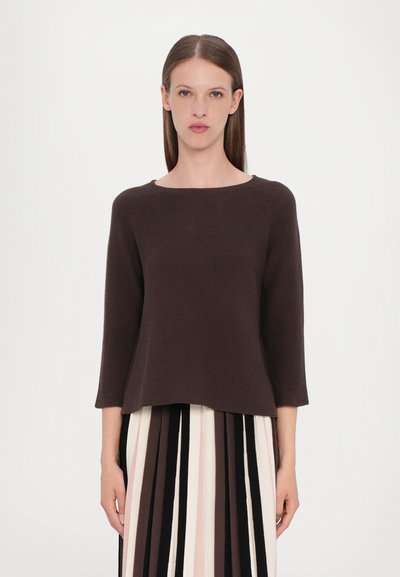 Brown, knitted, three-quarter sleeve top with a wide crew neckline, paired with a striped pleated skirt in pink, brown, and black tones.