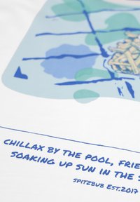 Witte stof met een blauw grafisch ontwerp en tekst: "CHILLAX BY THE POOL, FRIENDS," en een groen-blauw abstract patroon.