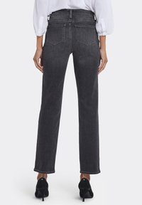 Mörkgrå jeans i denim med raka ben och midja i normalhöjd. Har två bakfickor och en skräddarsydd fåll. Kombineras med svarta högklackade skor.