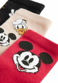 Tre par färgglada strumpor med tecknade figurer. Texturerat tyg med mönster: röd med Mickey Mouse, beige med Donald Duck, svart med olika motiv.