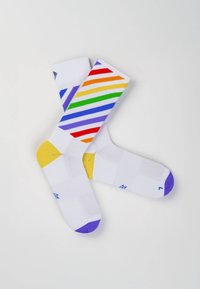 Weiße Socken mit diagonalen Regenbogenstreifen in Rot, Orange, Gelb, Grün, Blau und Lila. Gelbe Akzente an Ferse und Zehen. Atmungsaktives Material.