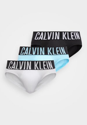 Drei Herren-Slips in Schwarz, Hellblau und Weiß mit schwarzen elastischen Bunds, die große weiße "Calvin Klein"-Logos zeigen.