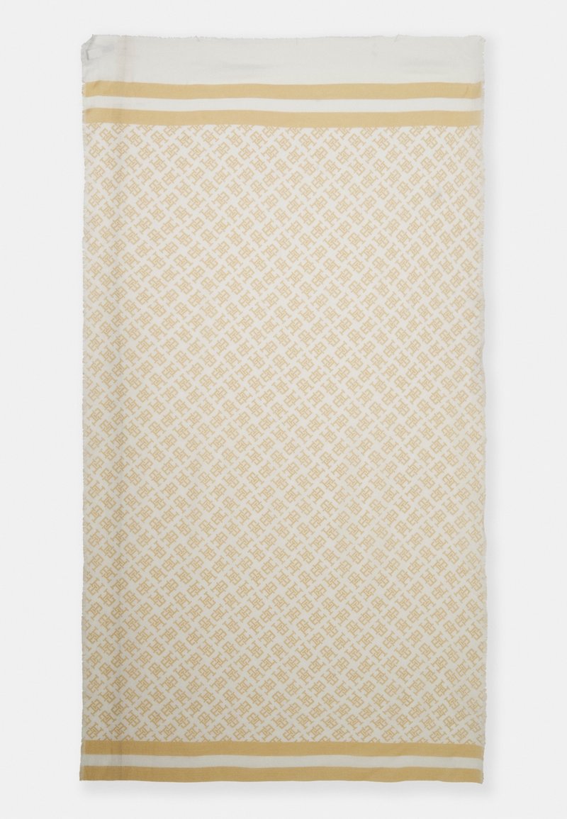 Tissu rectangulaire beige et blanc avec un motif géométrique répétitif et deux bandes parallèles beiges près des deux bords les plus courts.